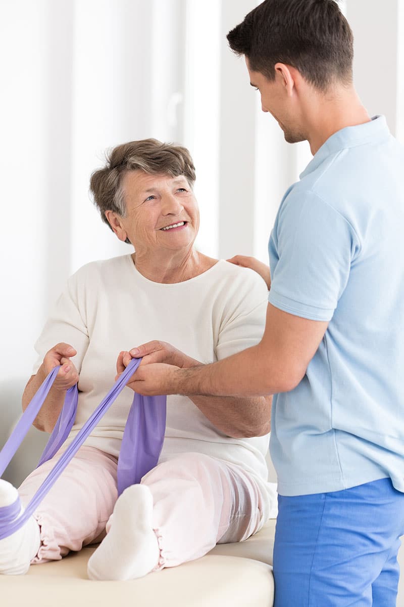 nurse helping a patient with physical therapy
