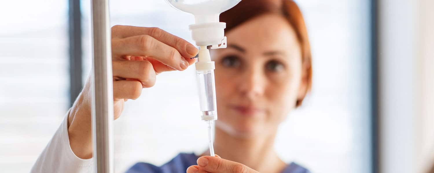 A nurse setting up and IV