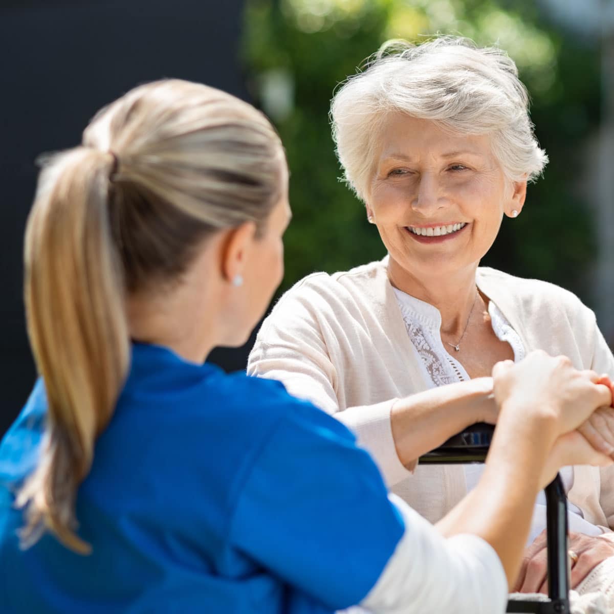 Elderly woman smiling at a nurse