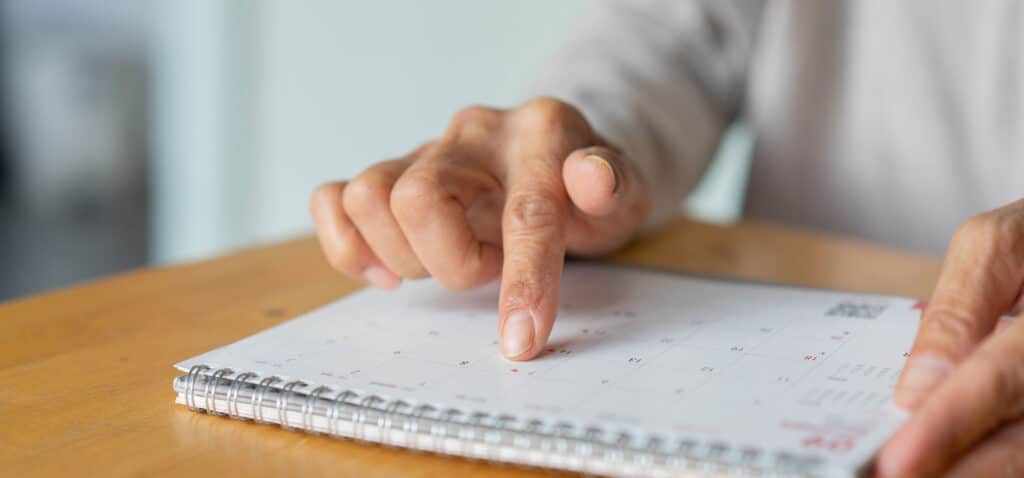 Elderly person looking at a calendar