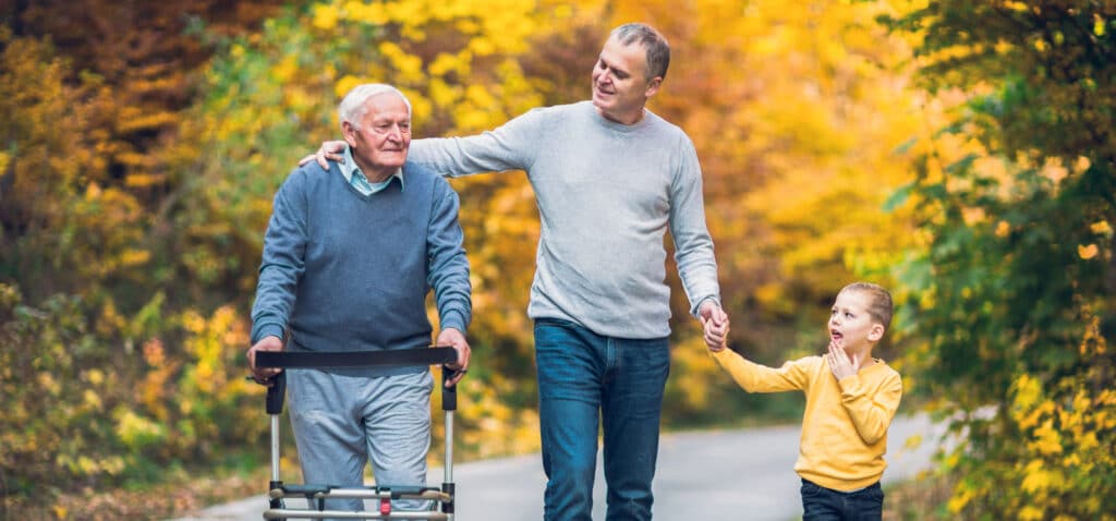 a man with his daughter walking with an elderly man