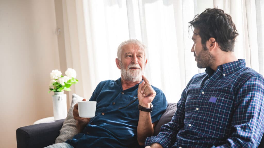 Elderly man talking to another man