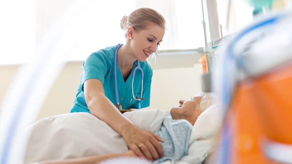 nurse helping a patient laying down