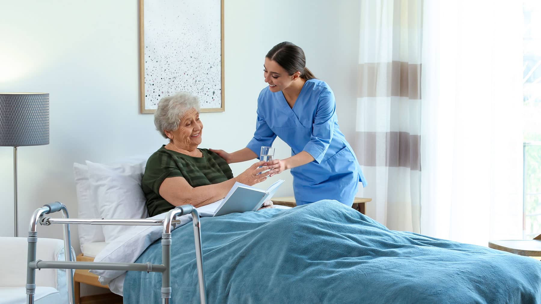 nurse giving an elderly patient some water