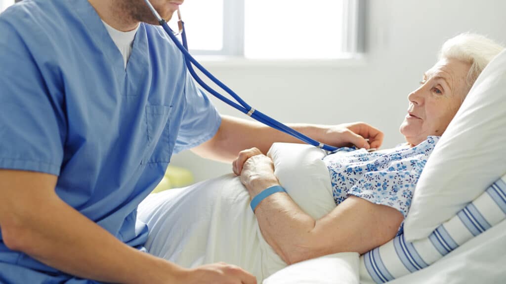 Nurse checking on an elderly patient